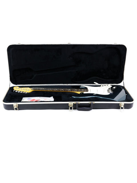 Inside a sleek guitar case lies a black and white Fender Strat Plus Deluxe, USA model from 1989.
