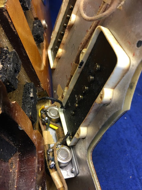 Interior view of a vintage 1960 Fender Jazzmaster guitar, emphasizing the metal cover detail.
