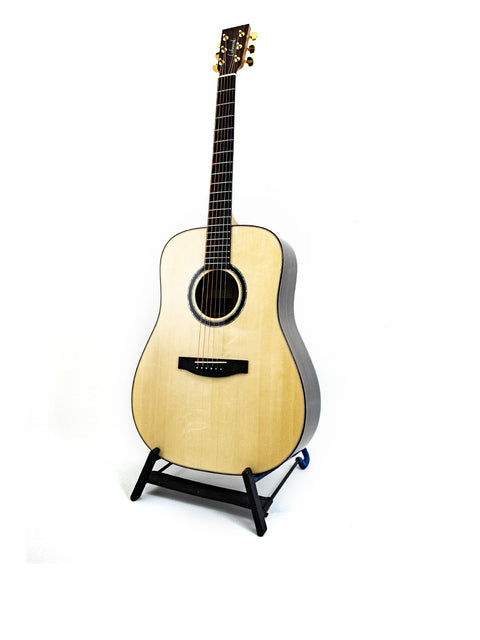 Lakewood D-32 Dreadnought guitar displayed on a stand with a white backdrop, showcasing its elegant design.