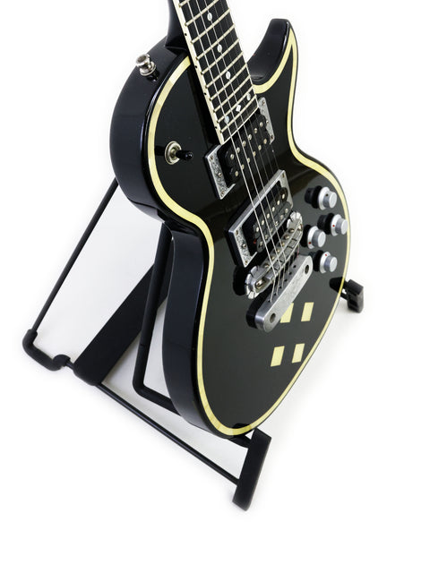 Stunning black electric guitar, Greco Zemaitis GZ-2600IF, elegantly displayed on a stand with a bright white backdrop.