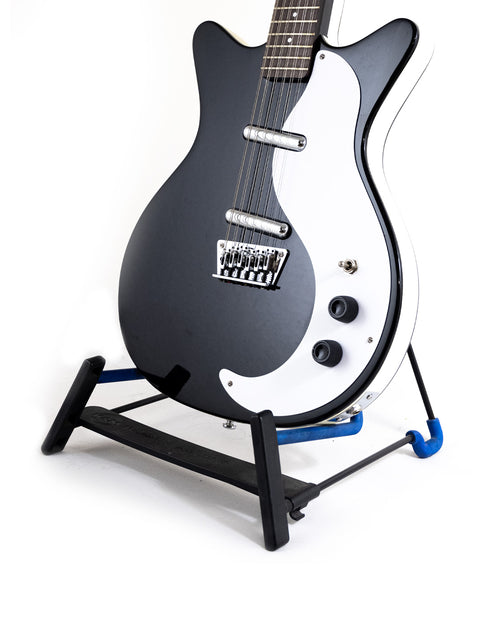 The Danelectro DC59 12-string guitar in black and white, beautifully positioned on a stand, highlighting its craftsmanship.
