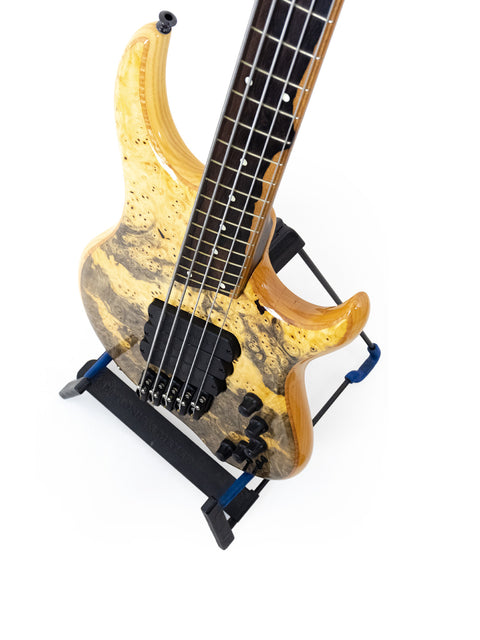 The Dingwall Z3 Buckeye Custom 5 String Bass guitar displayed on a stand, featuring a striking design against a white backdrop.