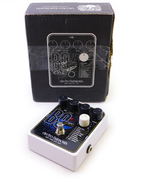 The Electro Harmonix B9 pedal features a sleek white and black design, housed in a compact box for easy use.