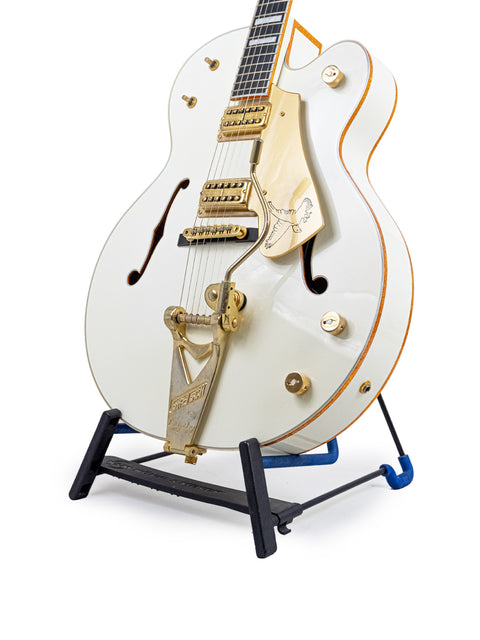 The Gretsch G7593 White Falcon guitar, white with a gold neck, stands proudly on a stand, crafted in Japan, 2012.