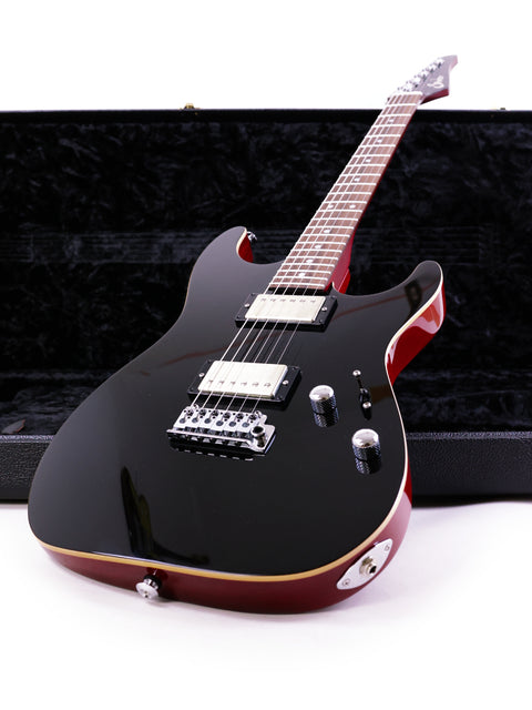 The Suhr Pete Thorn Signature electric guitar in black, highlighted by vibrant red strings, made in the USA, 2021.