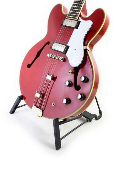 The striking red Epiphone 50th Anniversary 1962 Sheraton E212T guitar is displayed on a stand, highlighting its vintage charm.