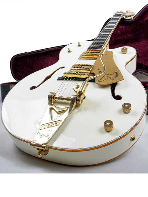 This image shows a Gretsch G-60 guitar, elegantly designed in white with gold hardware, made in Japan in 2012.