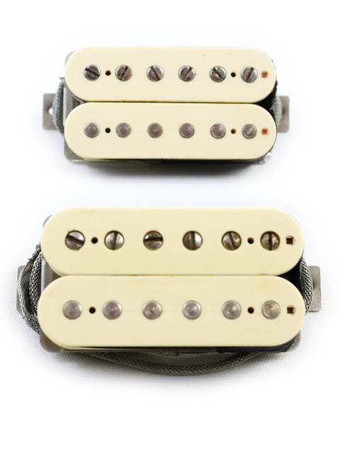 Two humbuckers with white covers set against a white background, representing Peter Florance Voodoo Humbucker pickups from 2005.