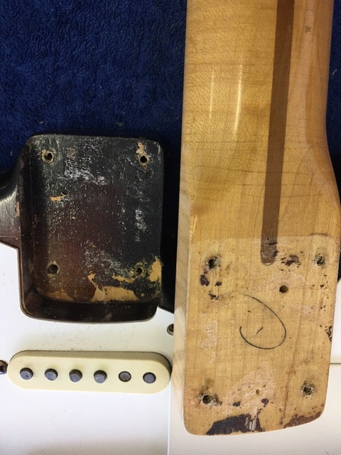 Vintage 1958 Fender Stratocaster guitar displaying a broken bridge and pickguard, emphasizing its classic appeal.
