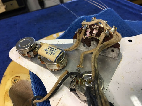 Vintage 1959 Fender Stratocaster guitar, blond finish, maple neck, equipped with a pickup and visible wiring.