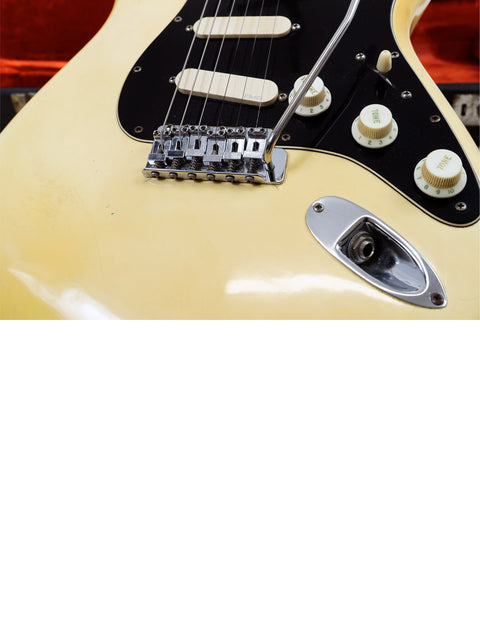 Vintage 1976 Fender Stratocaster electric guitar in yellow, accented by a black pickguard, perfect for music enthusiasts.