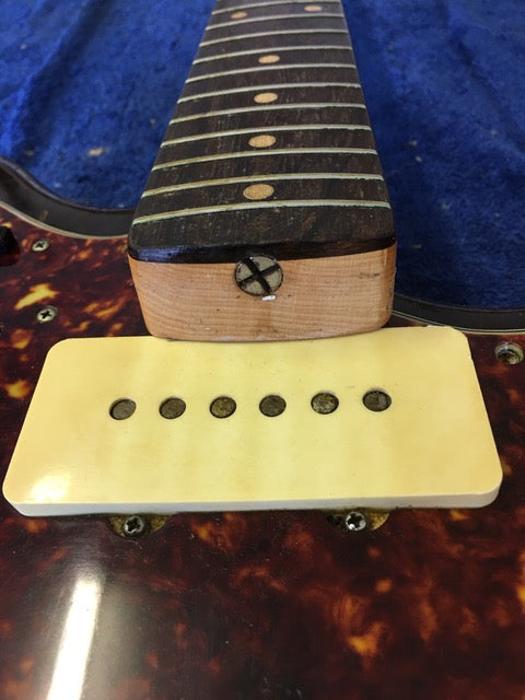 Vintage Fender Jazzmaster from 1960 USA, highlighting a wooden bridge and pickup, a symbol of classic guitar design.