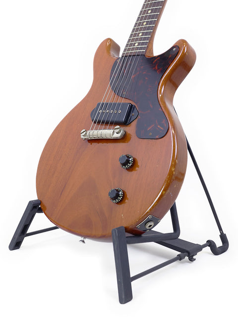 Vintage Gibson Les Paul Jr from 1959 resting on a black stand, emphasizing its timeless appeal and craftsmanship.