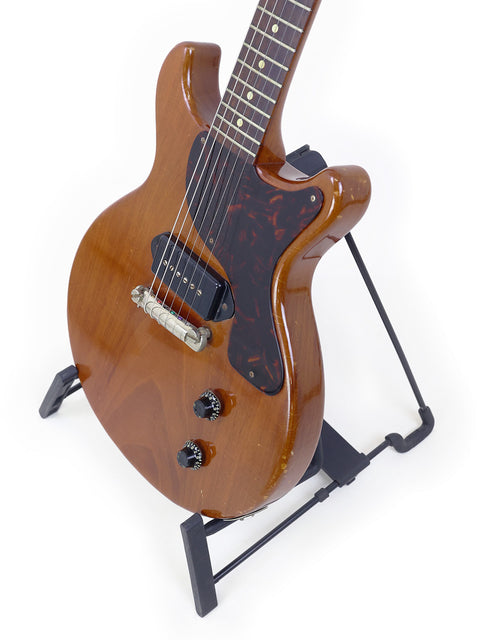 Vintage Gibson Les Paul Jr guitar on a stand against a clean white background, showcasing its classic design from 1959.