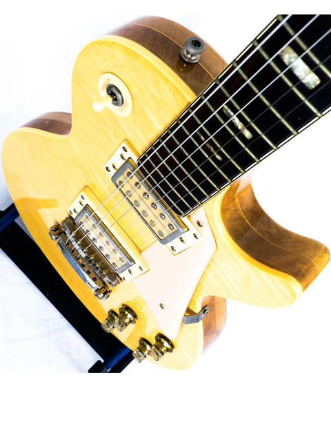 Yellow electric guitar, Univox Gimmie U-1988, Japan 1974-75, elegantly positioned on a wooden stand.