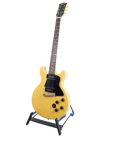 Yellow vintage 1958 Gibson Les Paul Special electric guitar showcased on a stand, highlighting its classic design.
