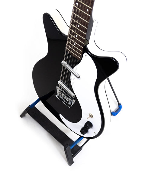 black and white Danelectro DC59 12-string guitar elegantly displayed on a stand, showcasing its unique design.