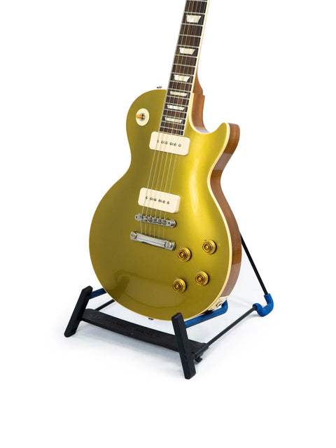 gold electric guitar on a stand, showcasing the Gibson Custom Historic Limited Edition VOS LPR-6 1956 Les Paul Reissue Goldtop.