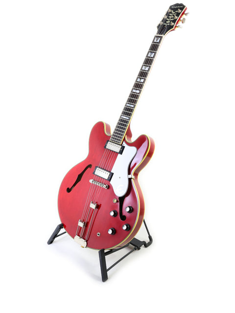 red Epiphone 50th Anniversary 1962 Sheraton E212T Reissue guitar displayed on a stand, showcasing its vibrant color and design.