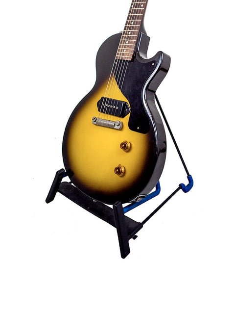 striking yellow and black Gibson '57 Les Paul Junior Reissue VOS guitar resting elegantly on a stand.