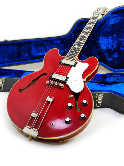 vibrant red guitar, the Epiphone 50th Anniversary 1962 Sheraton E212T Reissue, displayed in its case on a clean white surface.