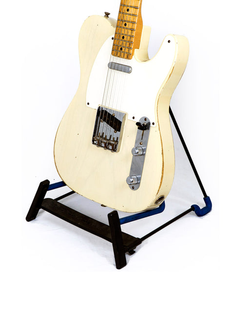 white Fender Custom Shop guitar on a blue stand, showcasing its sleek design and craftsmanship from 2006.
