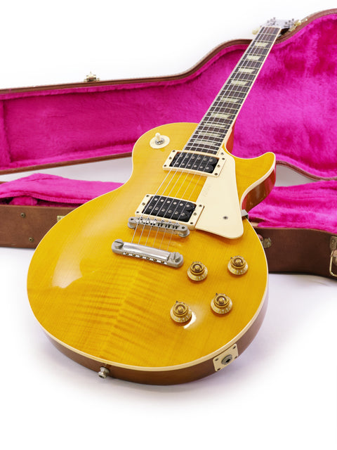 yellow Gibson Les Paul Classic 1960 Reissue electric guitar resting in a case, highlighting its classic design and color.