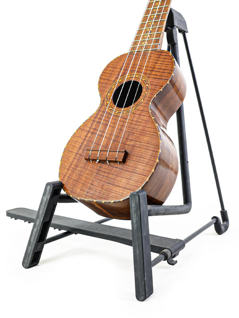 1920s Kumalae ukulele is perched on a stand, embodying the essence of Hawaiian music and craftsmanship.