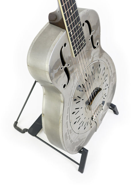 1934 National Style 'O' guitar elegantly resting on a stand, set against a simple white background.