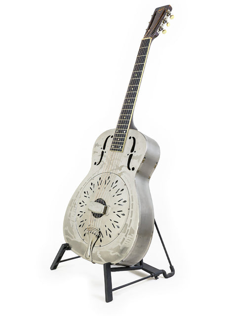 1934 National Style 'O' guitar resting on a stand, set against a bright white background.