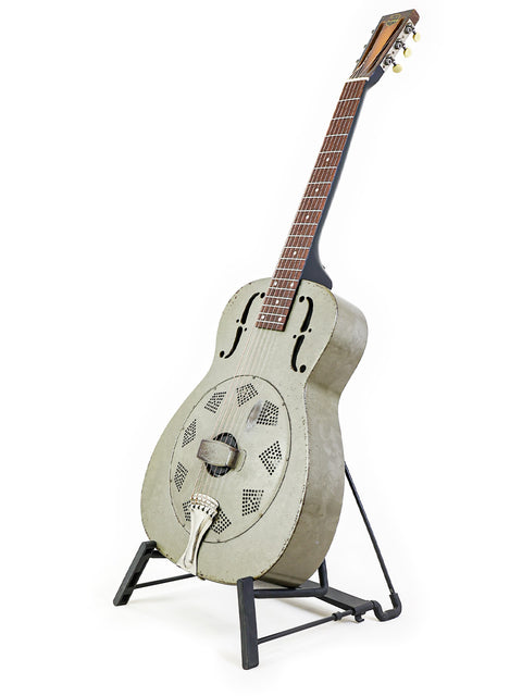 1936 National Duolian Resonator guitar resting on a stand, set against a simple white background.