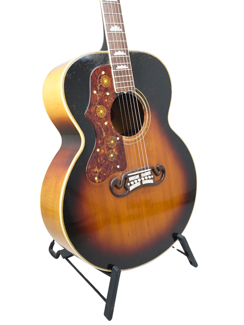 1955 Gibson J-200 Left-Handed guitar with a vibrant sunburst finish, showcased on a stand, highlighting its vintage charm.

