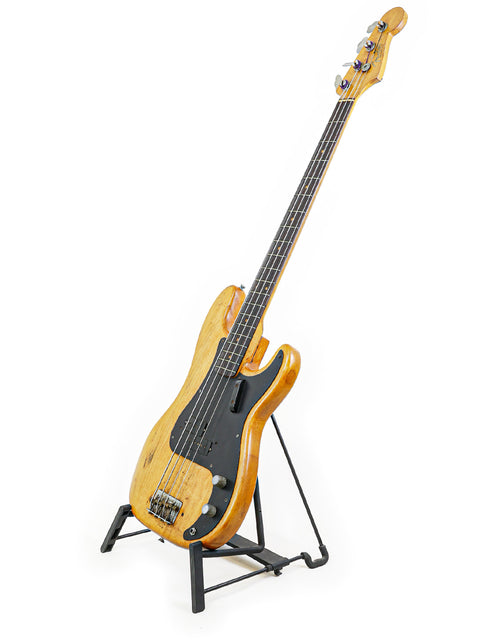 1963 Fender L-Series Precision Bass resting on a stand, set against a bright white background.