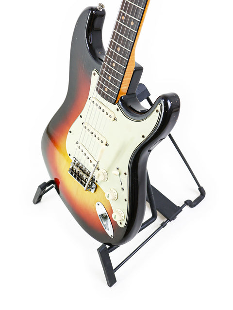 1963 Fender L-Series Stratocaster guitar elegantly positioned on a stand with a crisp white background.