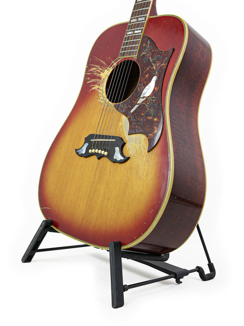 1968 Gibson Dove guitar resting on a stand, set against a plain white background.
