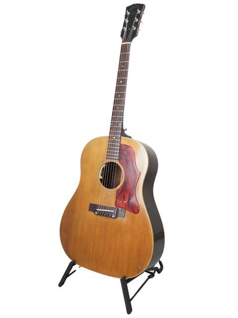 1968 Gibson J-50 guitar elegantly positioned on a stand, contrasting with a pristine white background.