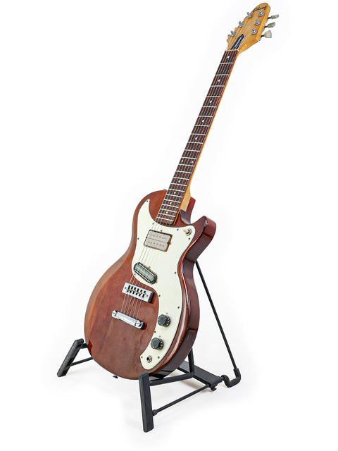 1975 Gibson Marauder guitar elegantly positioned on a stand with a simple white background.
