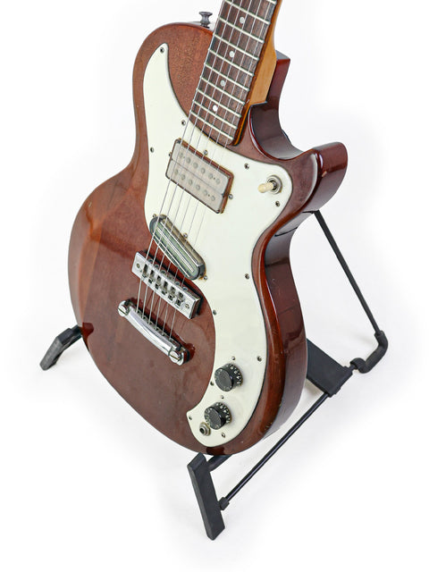 1975 USA-made Gibson Marauder guitar elegantly positioned on a stand with a white background.