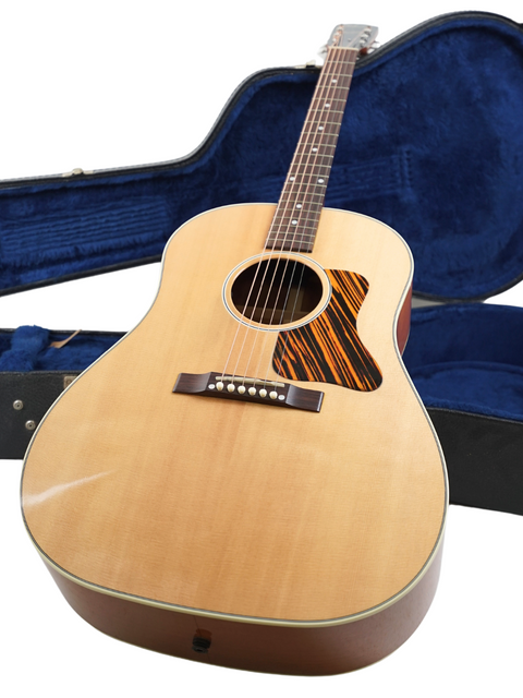 2013 Gibson J-35 guitar with a wooden body, displayed alongside its case, ideal for music lovers and collectors.