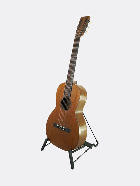 Wooden  Martin 2-17 guitar on a stand against a white background