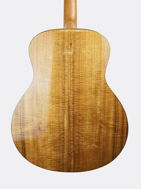 Close-up of a wooden R. Taylor Style 1 guitar on a white background