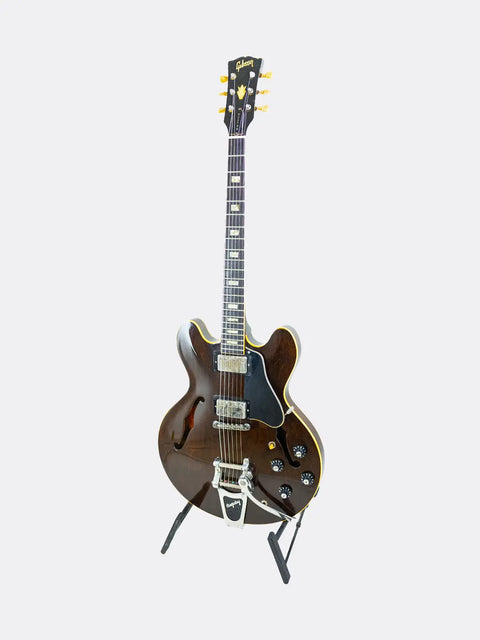 Gibson ES-335  guitar on a stand against a white background