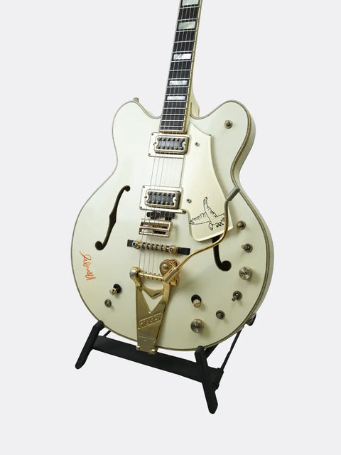 1972 Gretsch White Falcon with gold hardware on a stand against a white background