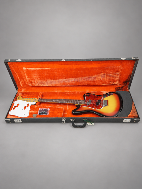 A vintage 1965 Fender Electric XII guitar securely placed in an eye-catching orange case, ready for its next gig.