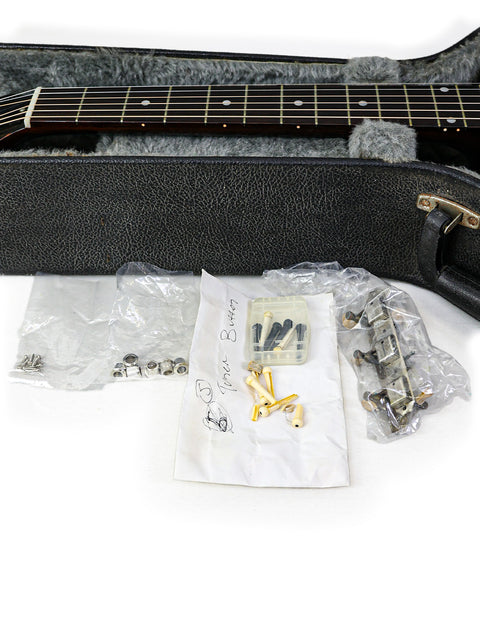 A 1954 Vintage Gibson LG-1 guitar nestled in its case alongside various accessories.