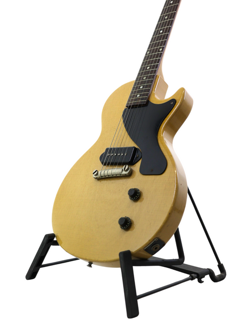 A 1956 Vintage Gibson Les Paul Jr TV Yellow guitar displayed on a stand, set against a pristine white backdrop.