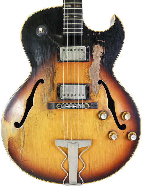 A 1962 Gibson ES-175D guitar featuring a sunburst finish and black pickguard, highlighting its vintage appeal.
