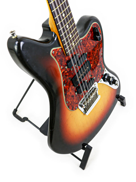 A 1966 vintage Fender Electric XII guitar with a beautiful sunburst finish, showcased on a stand.

