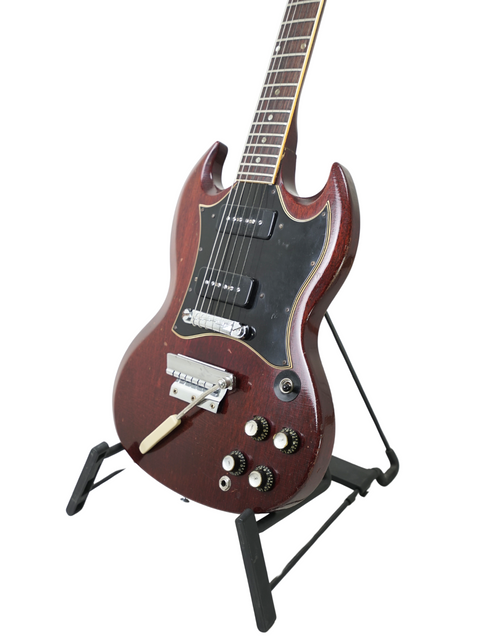 A 1967 Vintage Gibson SG Special guitar elegantly displayed on a stand with a contrasting black background.