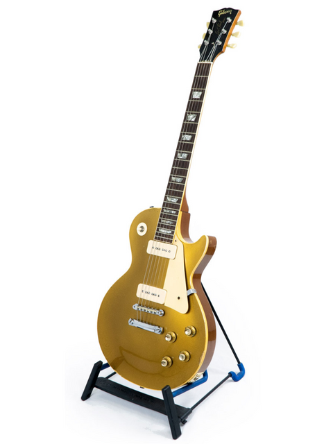 A 1968 vintage Gibson Les Paul Standard Goldtop guitar resting on a stand, set against a stark white background.